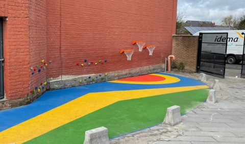 Mur d'escalade et paniers de basket dans la cour