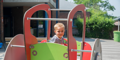 enfant en maternel qui joue à la récréation dans un module de jeu